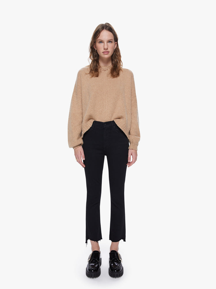 Front full body view of a women's camel brown knit sweater featuring a scoop neck, a center seam, and a loose fit.