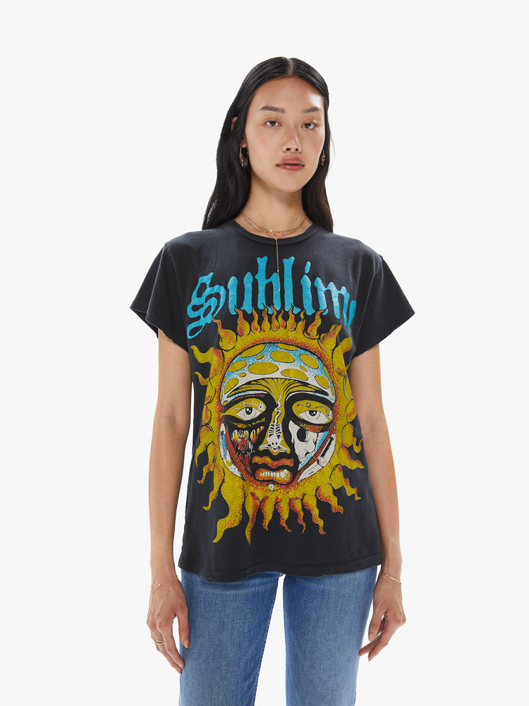 Front view of a woman wearing a faded black crew neck tee featuring a large "Sublime" sun graphic.