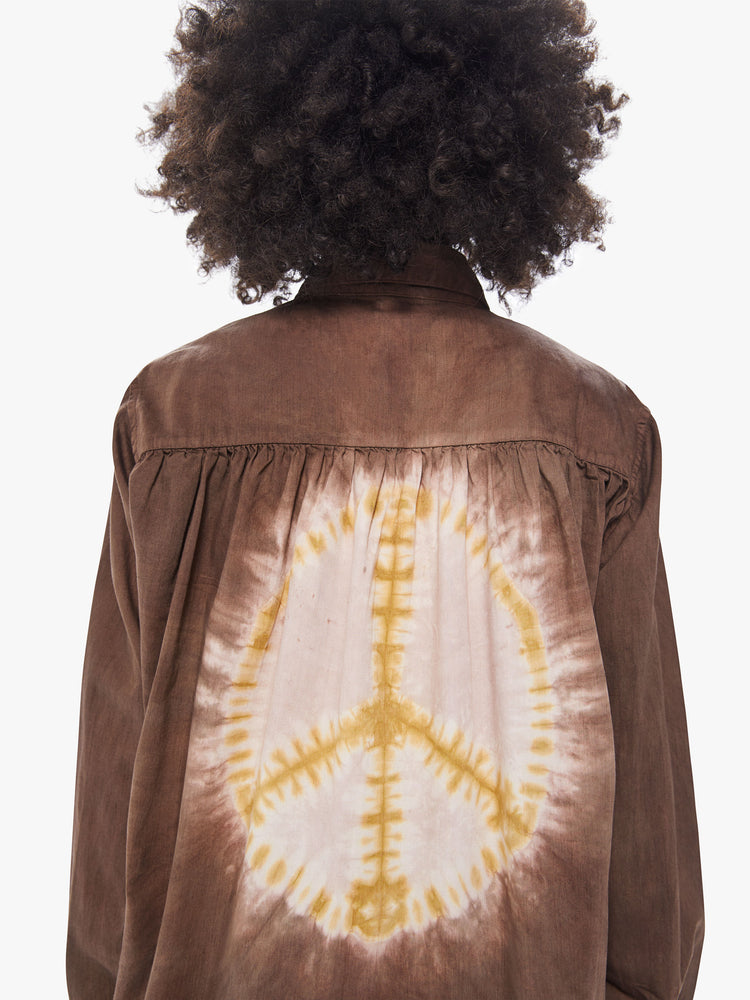 Back detail view of a women's dark brown shirt with a tie-dye peace sign featured at center back