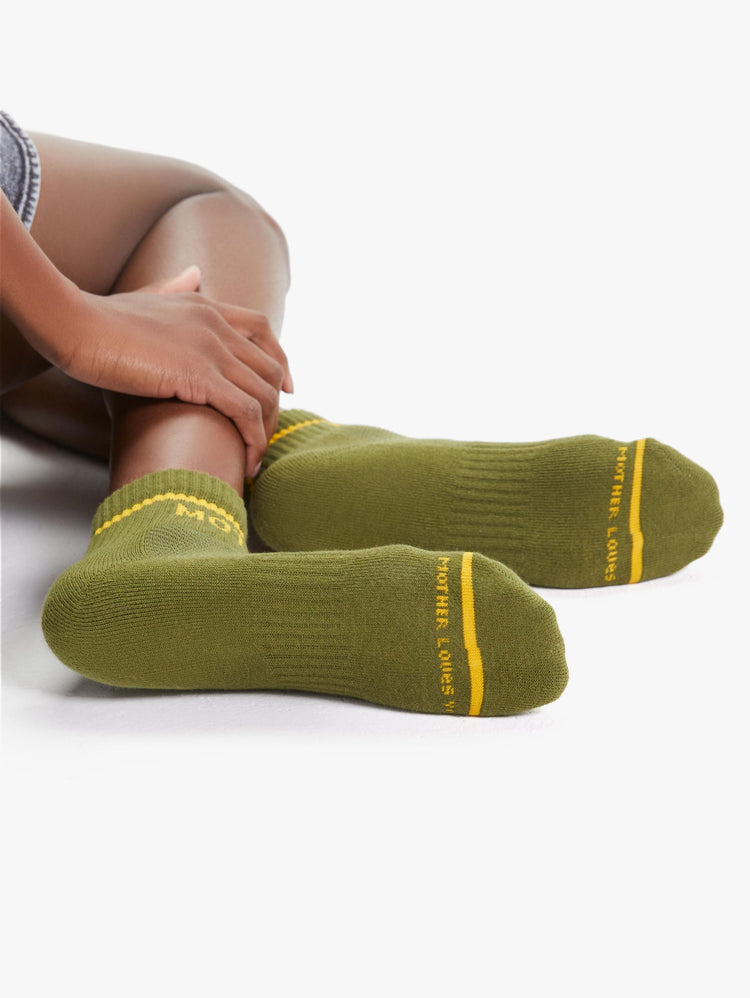 DETAIL VIEW WOMEN'S ANKLE SOCKS IN DARK GREEN WITH YELLOW LETTERING
