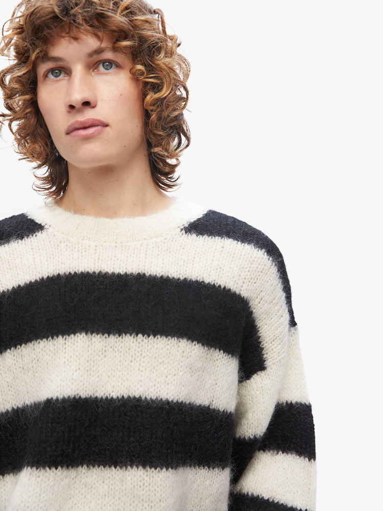 Front close up view of a mens knit sweater featuring black and white stripes.
