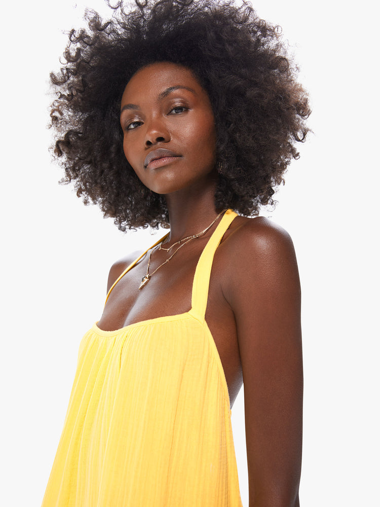 Front detail view of a women's yellow halter midi dress with open back