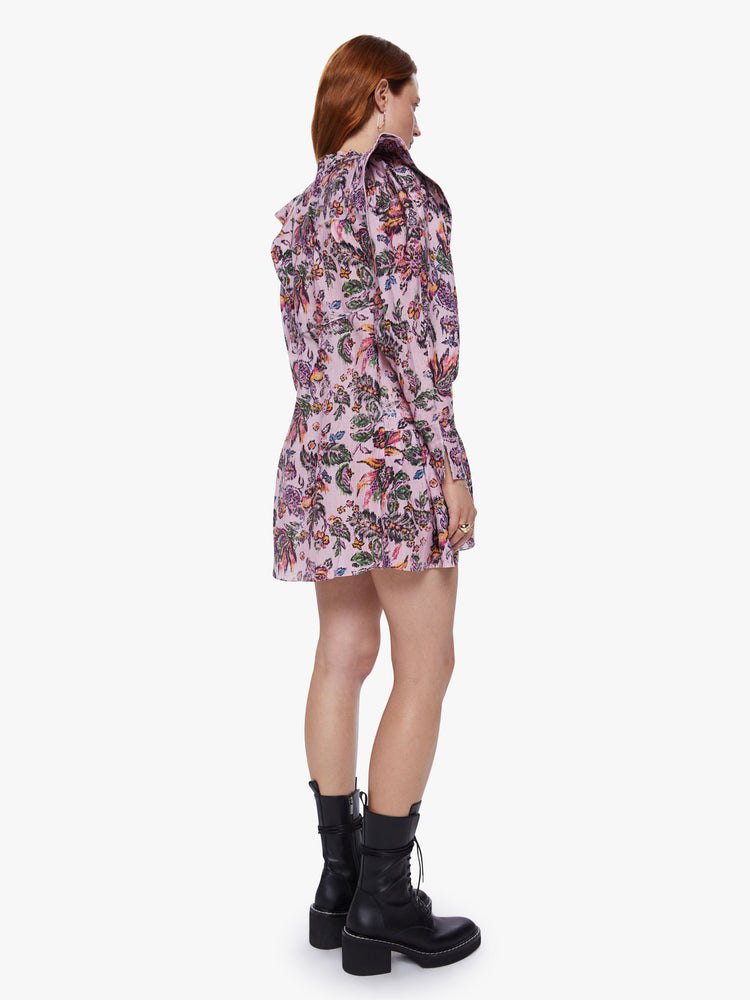 Back view of a womens pink floral dress featuring long sleeves and a wide ruffle at the hem.