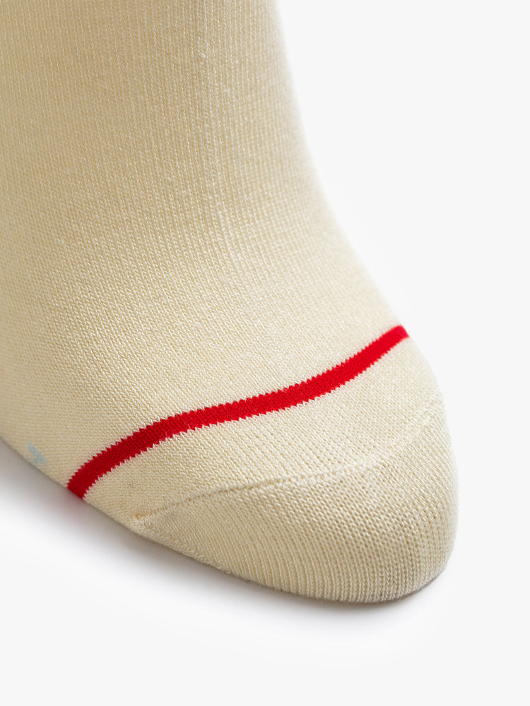 Front close up view of a pair of off white socks featuring a red and blue graphic.
