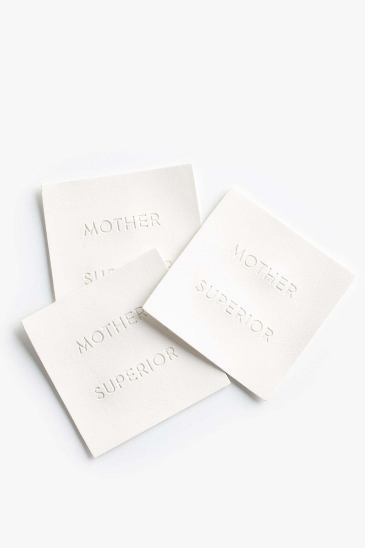 STACK OF WHITE MOTHER SUPERIOR LABELS.