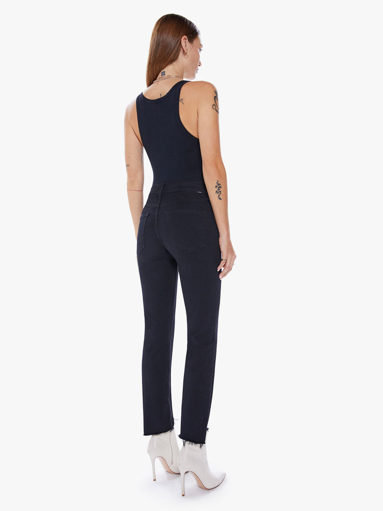 Back view of a womens black jean featuring a mid rise, straight leg, and an ankle length crop step hem.