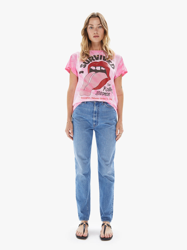 Front full body view of a woman wearing a pink tie dye crew neck tee featuring a large The Rolling Stones concert graphic.