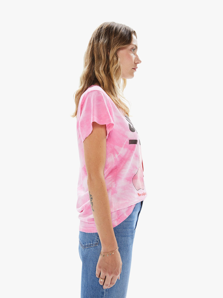 Side view of a woman wearing a pink tie dye crew neck tee featuring a large The Rolling Stones concert graphic.