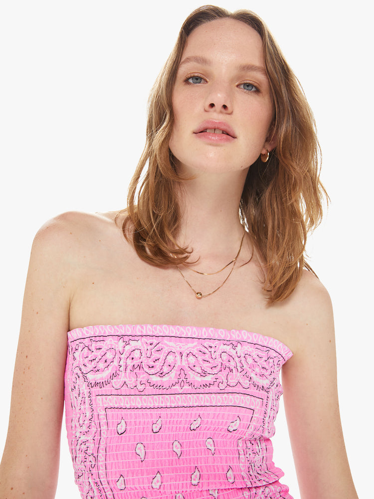 Front close up view of a women wearing a pink elastic tube top featuring a light pink bandana print.