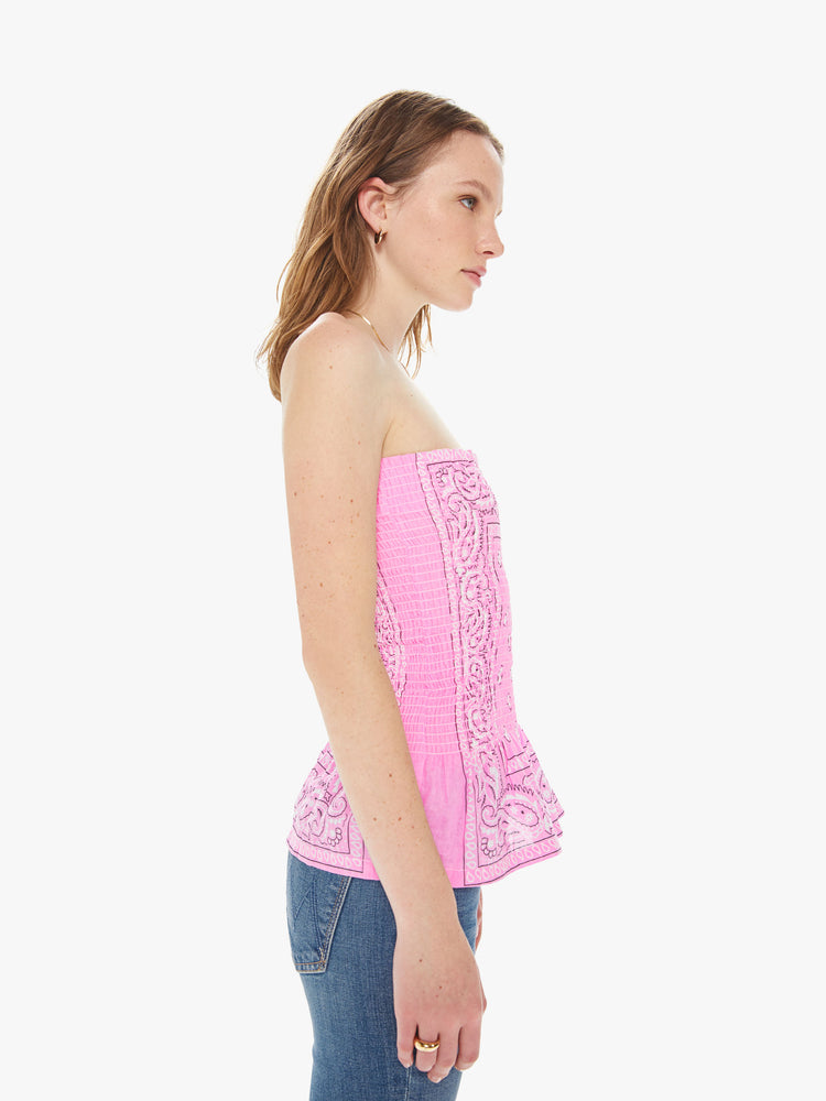 Side view of a women wearing a pink elastic tube top featuring a light pink bandana print.