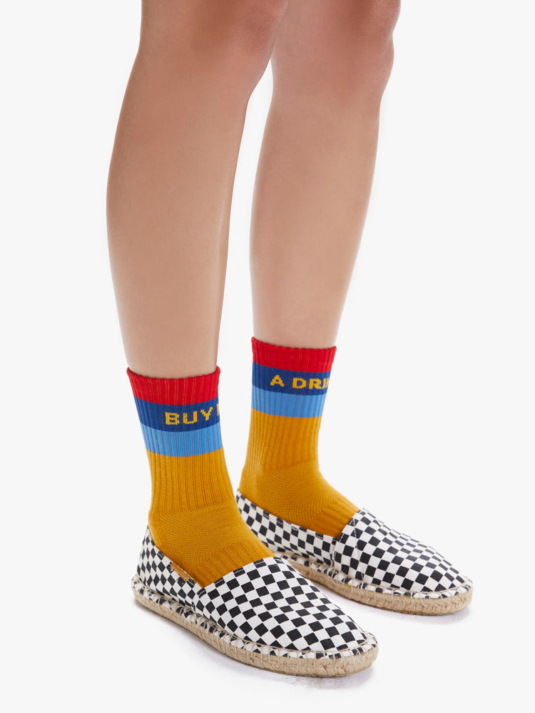 SIDE VIEW WOMEN'S YELLOW BLUE AND RED SOCK READING "BUY ME A DRINK"