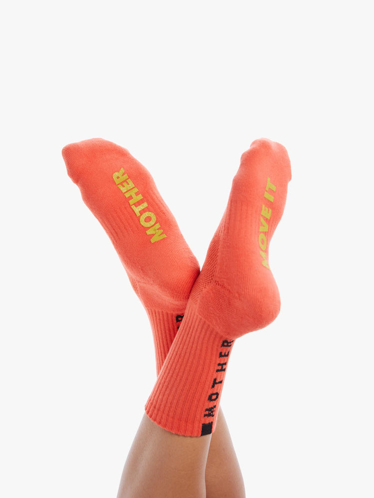 DETAIL VIEW WOMEN'S MID CALF LENGTH ORANGE SOCK WITH YELLOW SIDE MOVE IT LETTERING WITH BOTTOM BLACK MOTHER LETTERING
