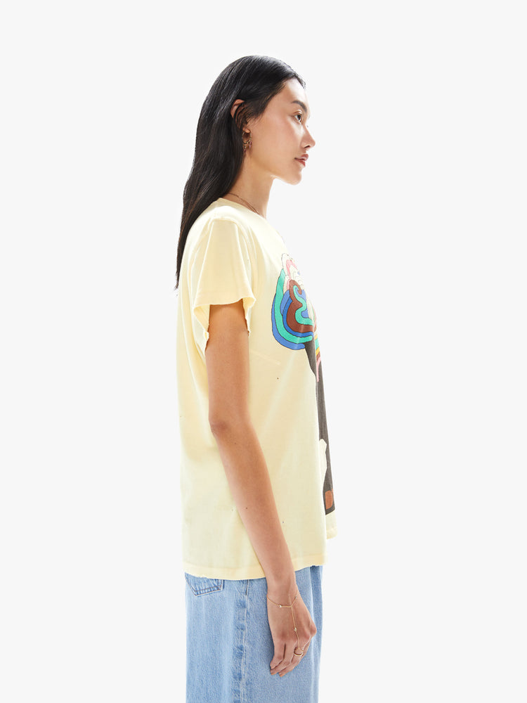 Side view of a woman wearing a faded yellow crew neck tee with a large colorful Bob Dylan graphic.
