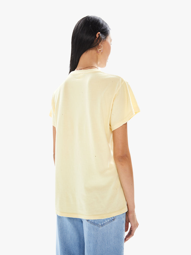 Back view of a woman wearing a faded yellow crew neck tee with a large colorful Bob Dylan graphic.