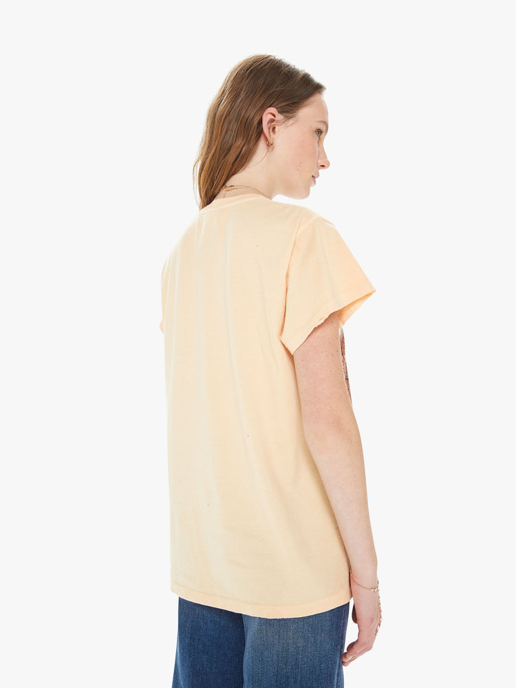 Back view of a woman wearing a faded orange crew neck tee featuring an oversized fit and a large "THE doors" graphic.