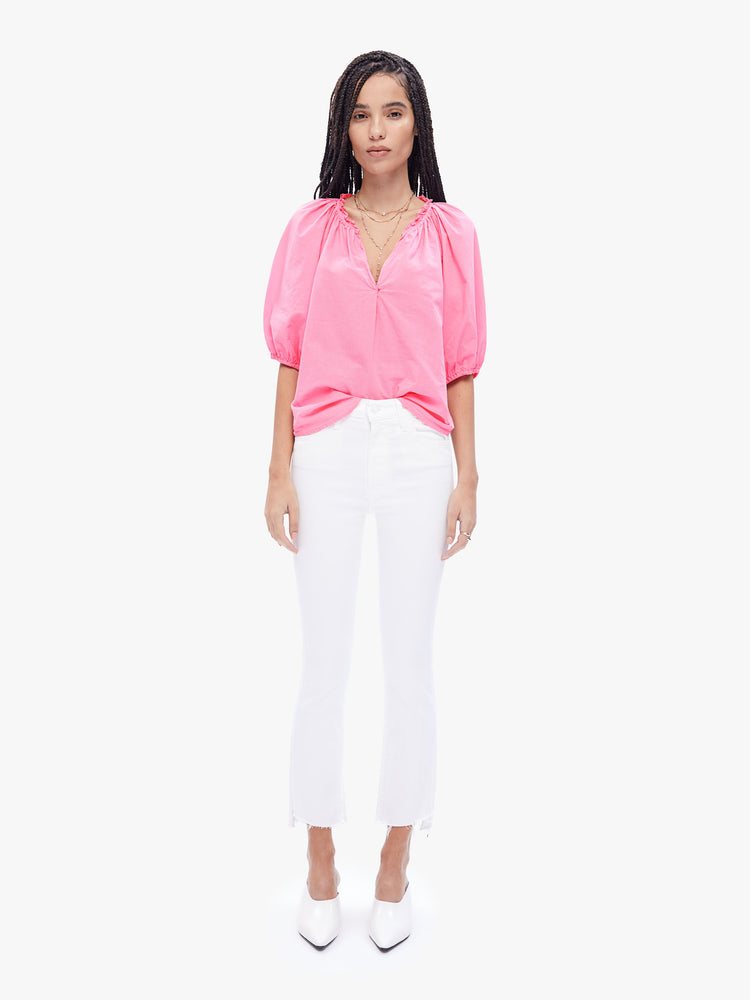 Full body view of a woman in effortless top from XiRENA, made from 100% cotton in a baby pink hue, the blouse features a ruffled collar with a deep Vneck, elbow-length balloon sleeves and a loose fit