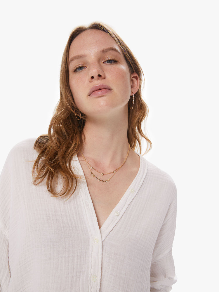 Front close up view of  a woman wearing a white button down top featuring a deep v.