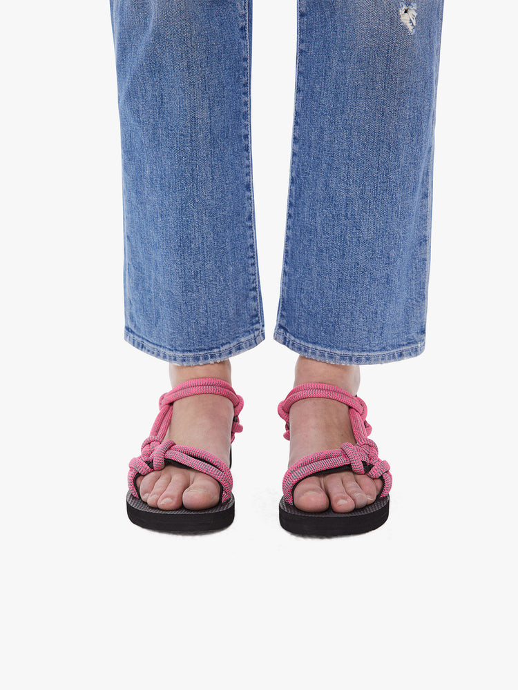 Front view of a woman wearing velcro sandals featuring a black foam sole and thick pink rope straps.