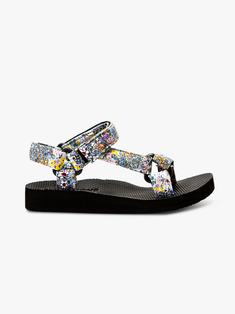 Side view of a velcro sandal featuring a black foam sole and a pastel floral print.