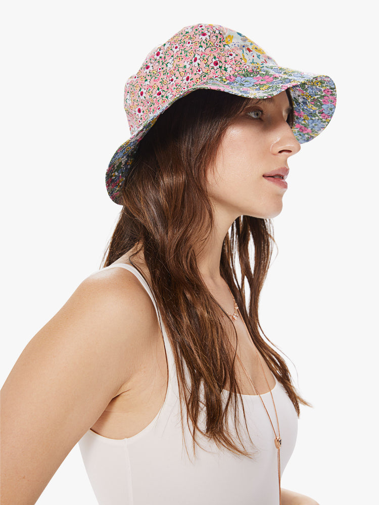 Profile view of a woman wearing a bucket hat featuring pieced assorted floral prints.