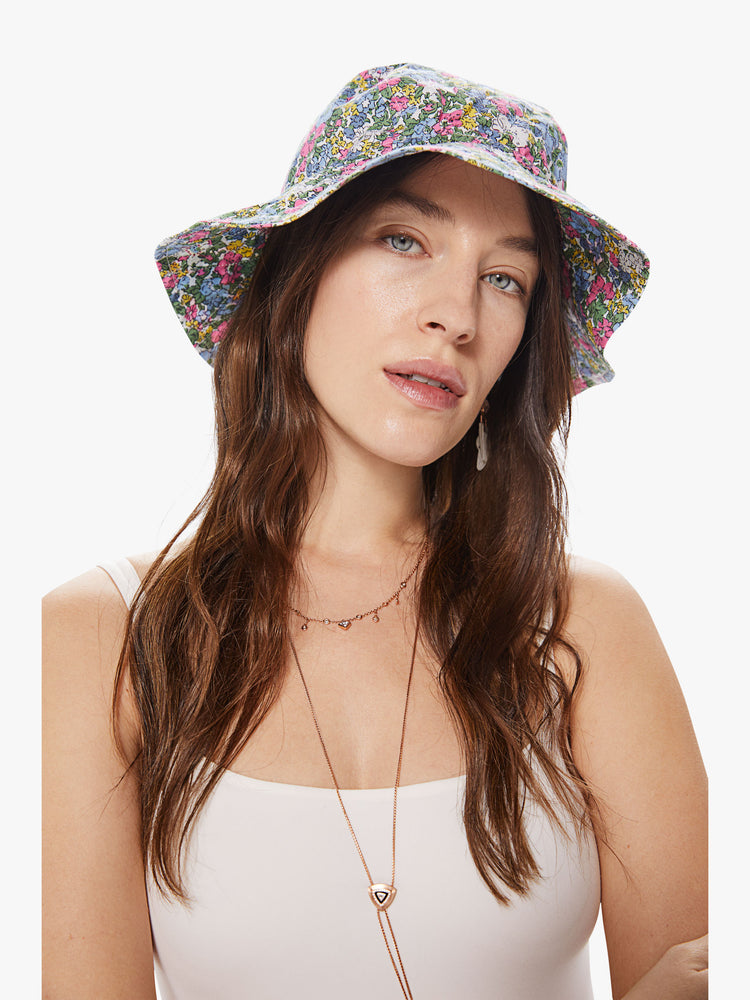 Front view of a woman wearing a bucket hat featuring pieced assorted floral prints.
