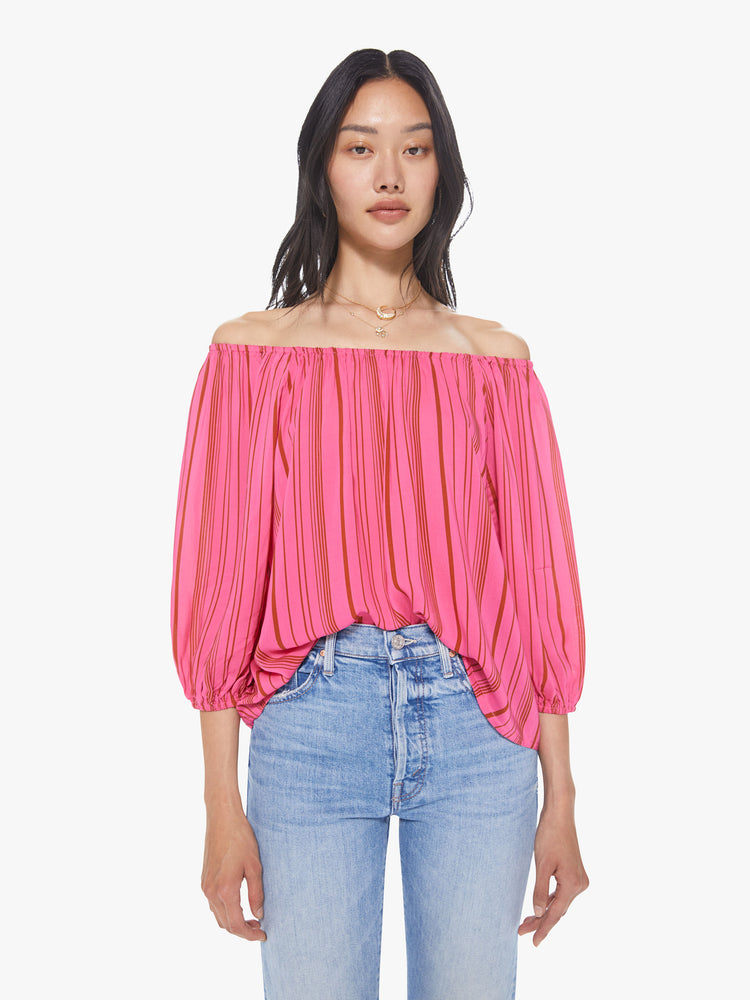 Front view of a women's bright pink off-shoulder blouse with red vertical stripes and 3/4 sleeves
