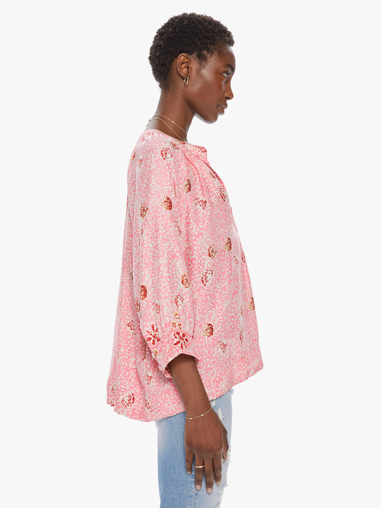 Side view of a women's light pink 3/4 sleeve blouse with all-over floral print