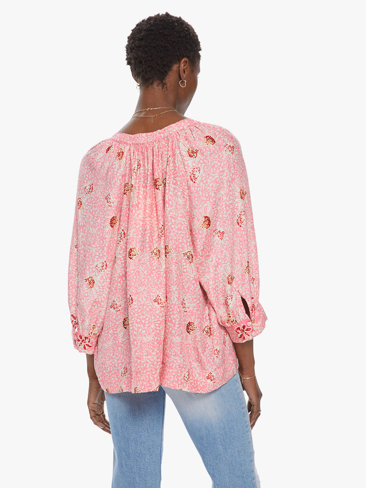 Back view of a women's light pink 3/4 sleeve blouse with all-over floral print