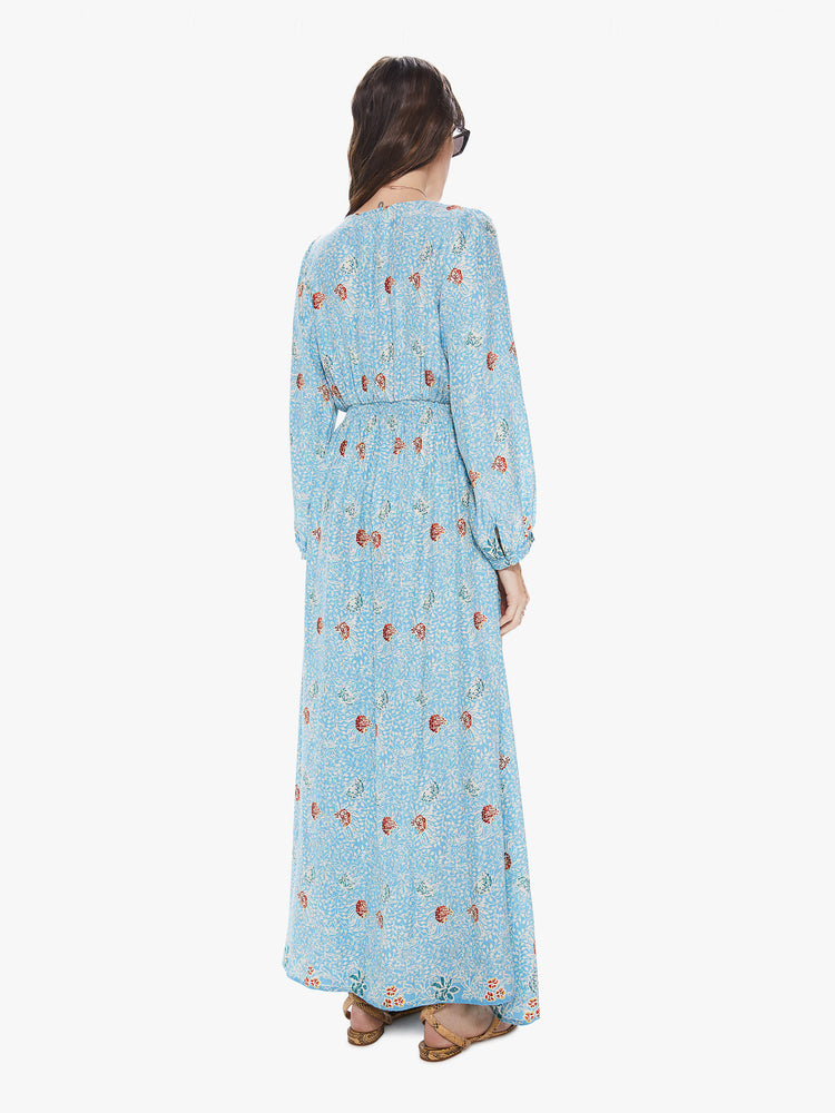 Back view of a women's light  blue maxi dress with all-over floral print and long sleeves