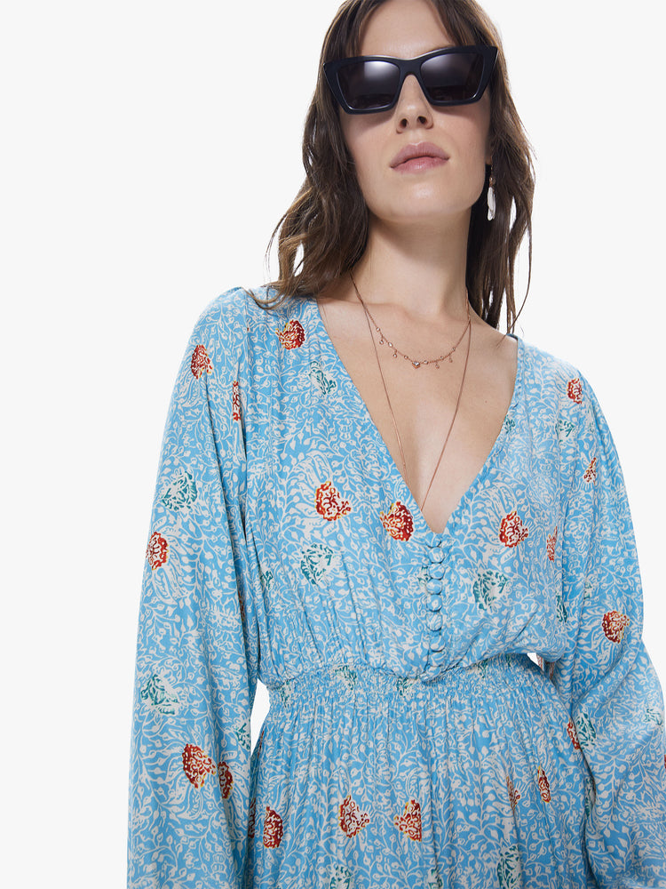 Front detail view of a women's light  blue maxi dress with all-over floral print and long sleeves