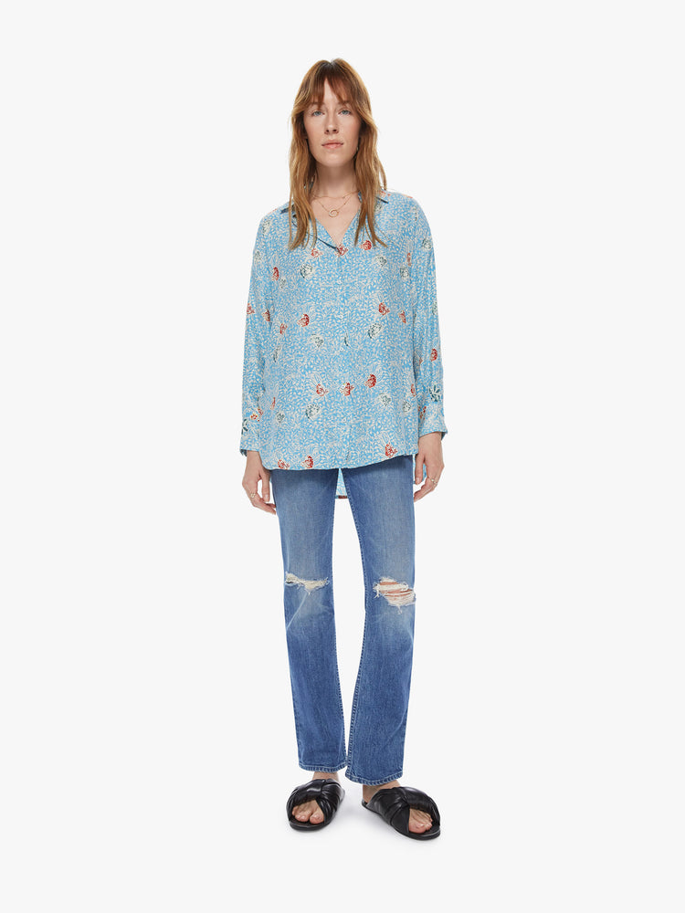 Full front view of a women's light blue button front long sleeve shirt with an all over floral print