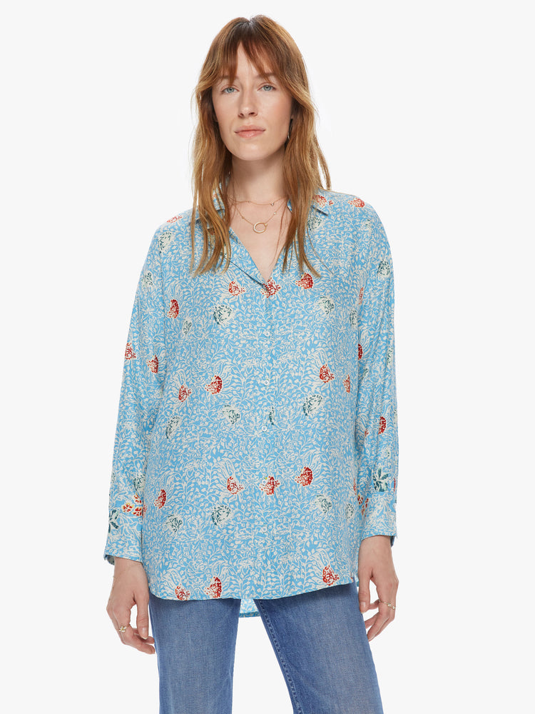Front view of a women's light blue button front long sleeve shirt with an all over floral print