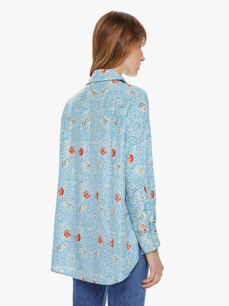 Back view of a women's light blue button front long sleeve shirt with an all over floral print