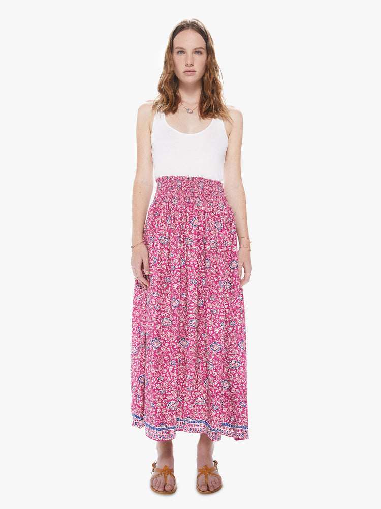 Front view of a woman wearing a pink floral print skirt featuring a high elastic waistband.