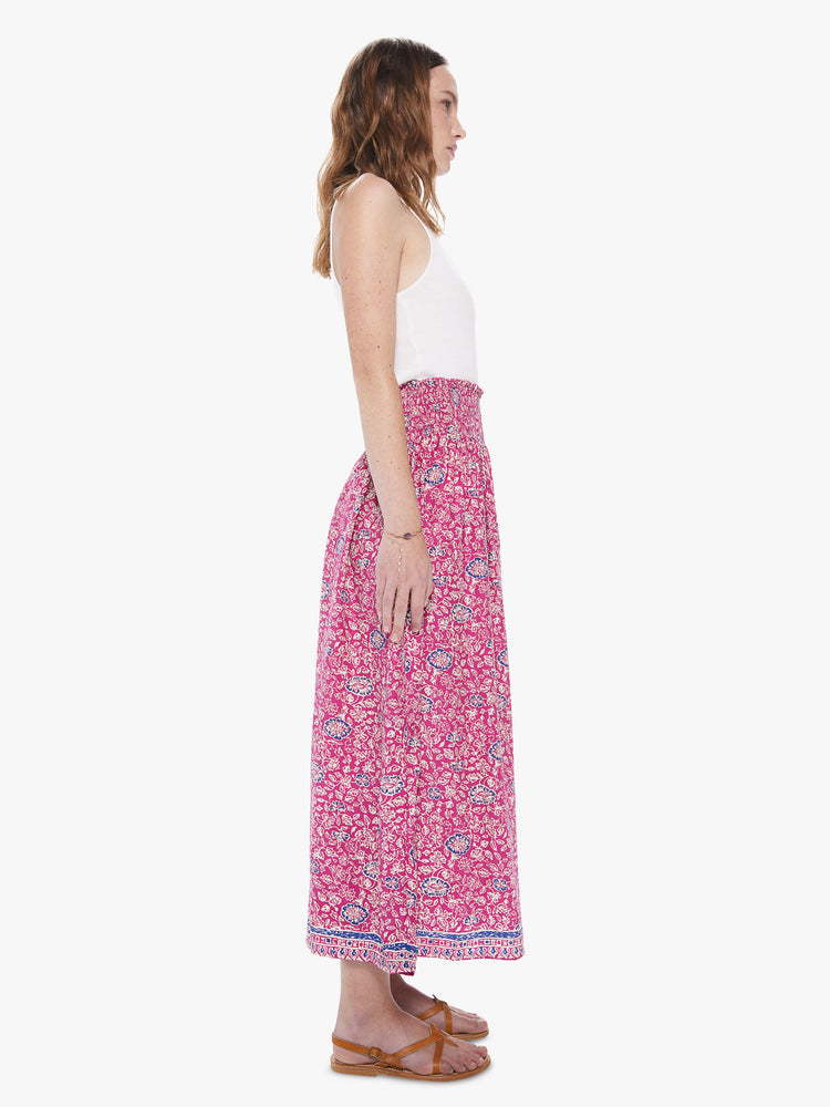 Side view of a woman wearing a pink floral print skirt featuring a high elastic waistband.