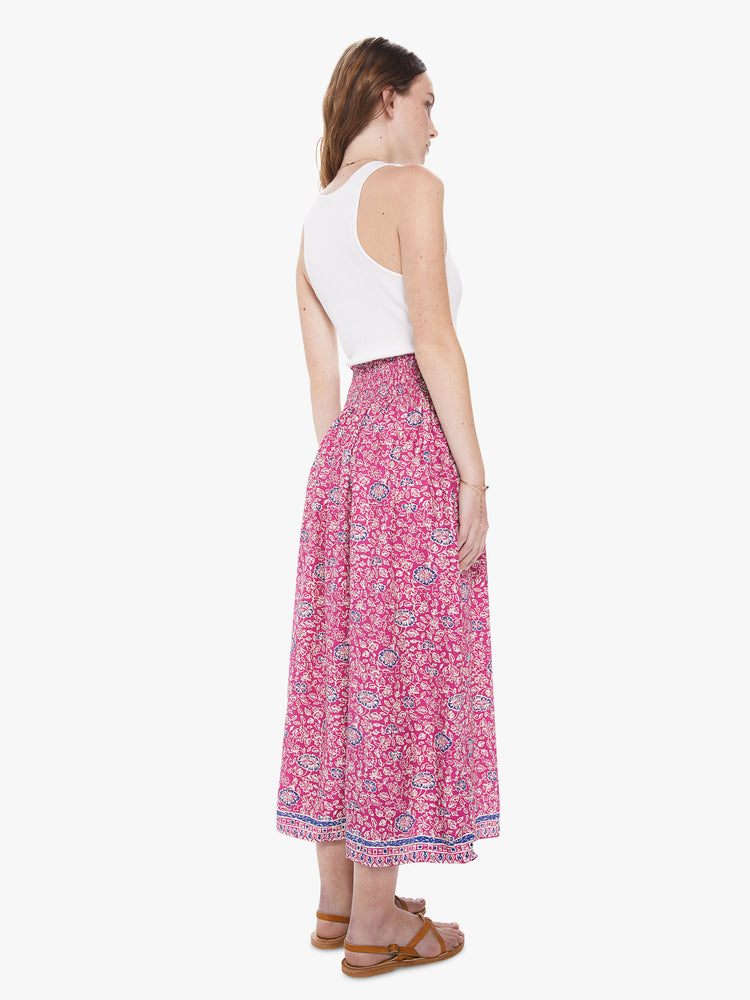 Back view of a woman wearing a pink floral print skirt featuring a high elastic waistband.