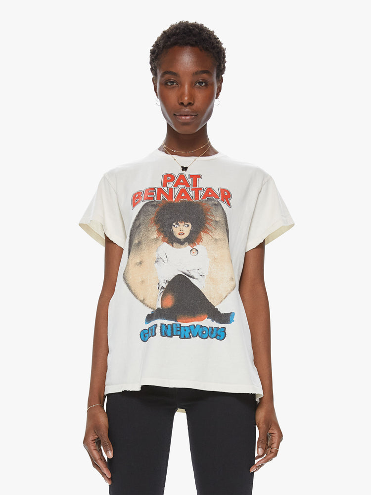 Front view of a woman wearing an off white crew neck tee featuring a vintage band inspired graphic reading "PAT BENATAR" and "GET NERVOUS" with distressed details.