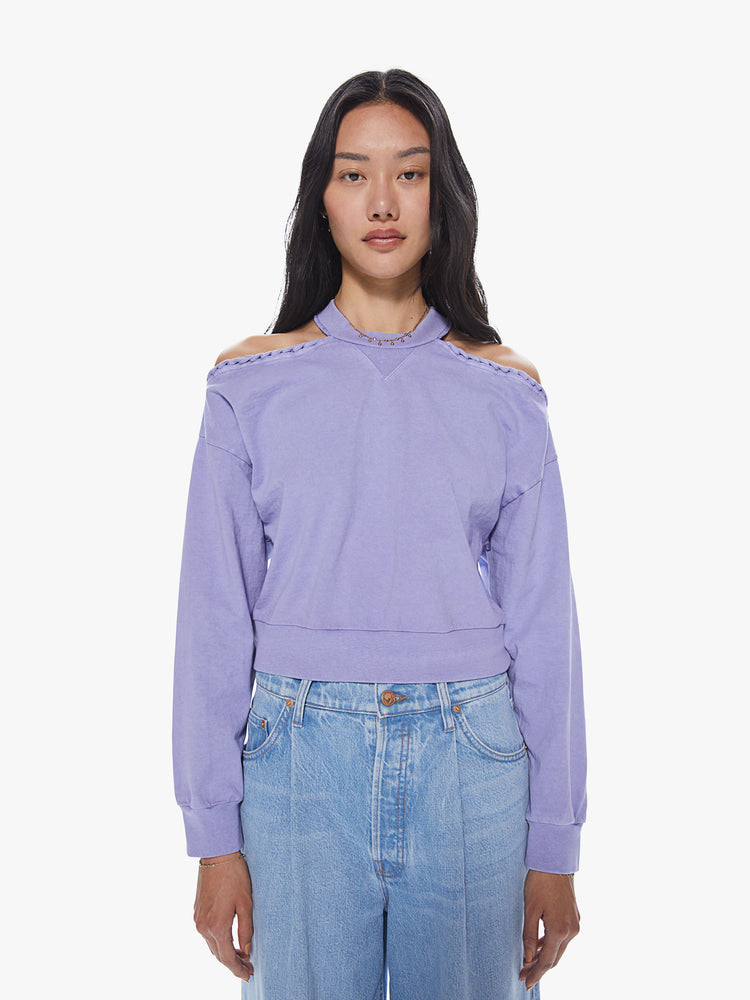 Front view of a woman wearing a cropped lavender pullover featuring dropped sleeves and cut-out shoulders.
