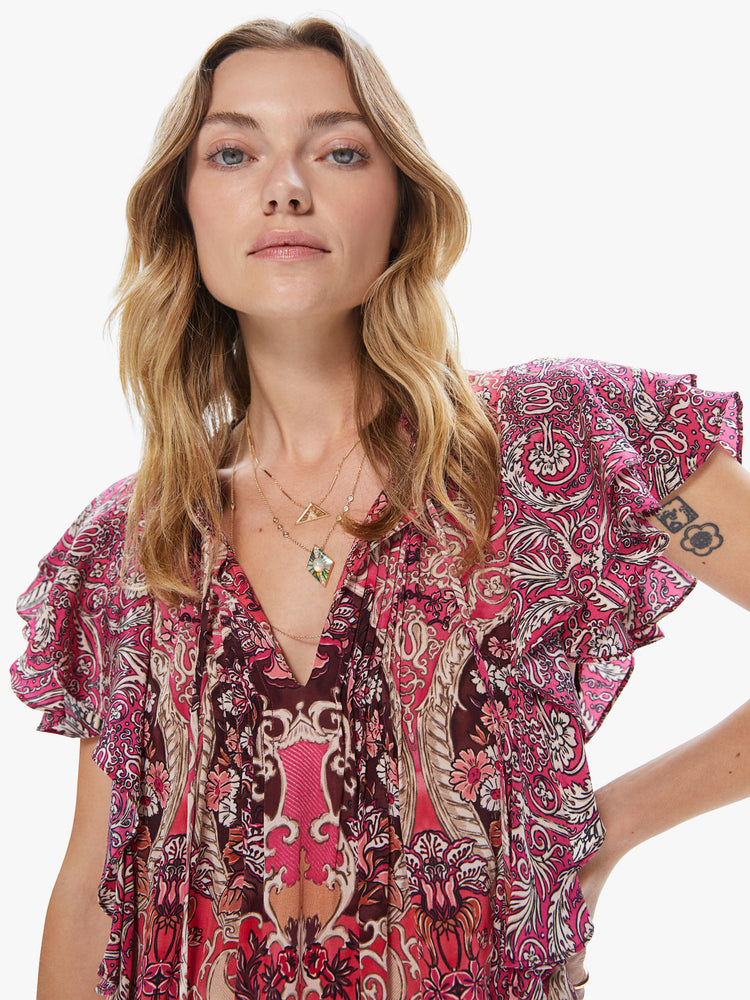Front detail view of a women's pink top with an all-over paisley print and ruffle sleeves