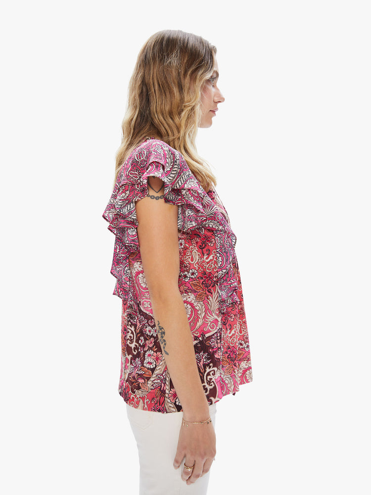 Side view of a women's pink top with an all-over paisley print and ruffle sleeves