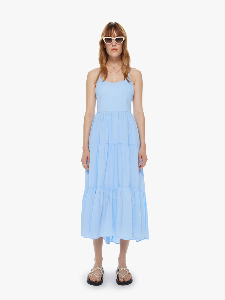 Front view of women's light blue tiered midi dress with lace up open back detail