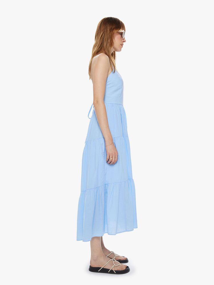 Side view of women's light blue tiered midi dress with lace up open back detail