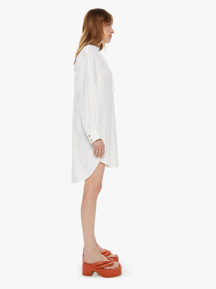 Side view of a women's long sleeve mini dress with lace up collar detail
