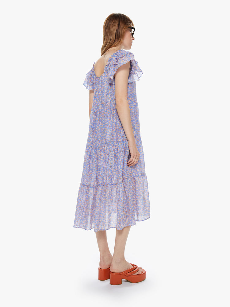 Back view of a women's light blue tiered midi dress with all-over floral print and ruffled sleeves