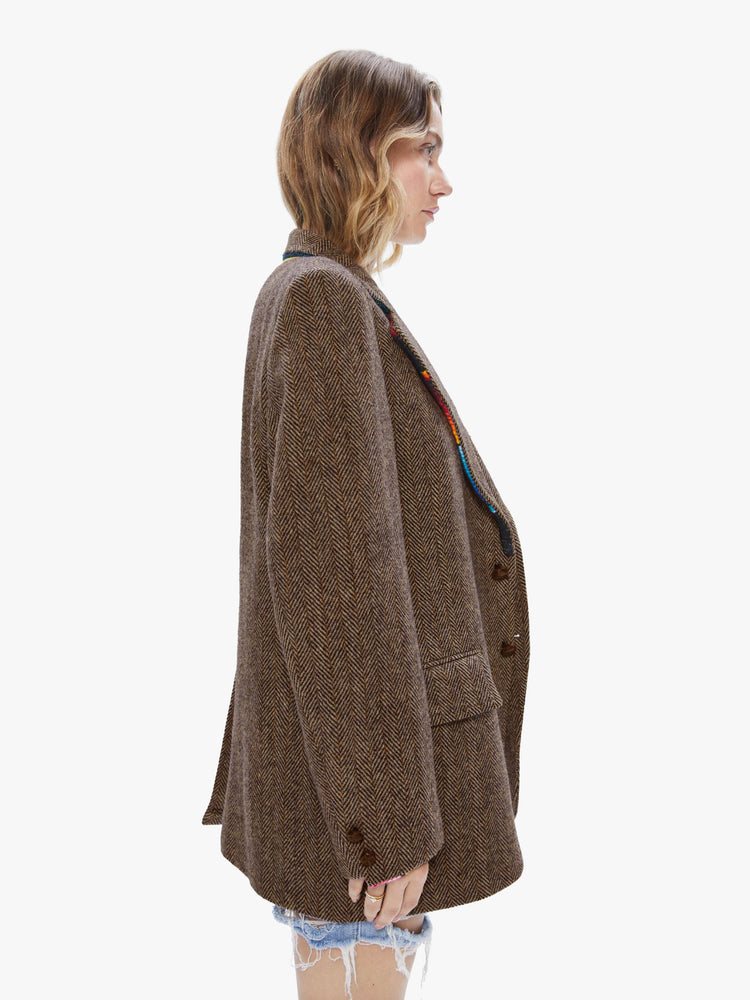 Side view of a woman wearing a vintage tweed blazer with sarape blanket trim details and an oversized fit.