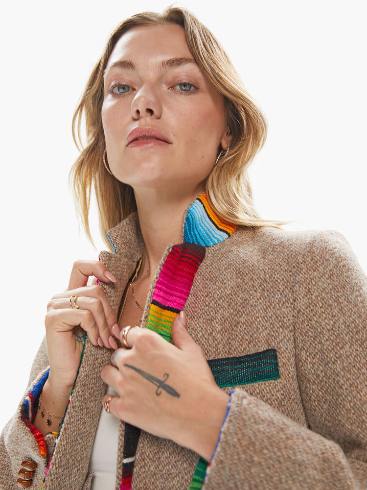 Front close up view of a woman wearing a light brown vintage tweed blazer with sarape blanket trim details and an oversized fit.