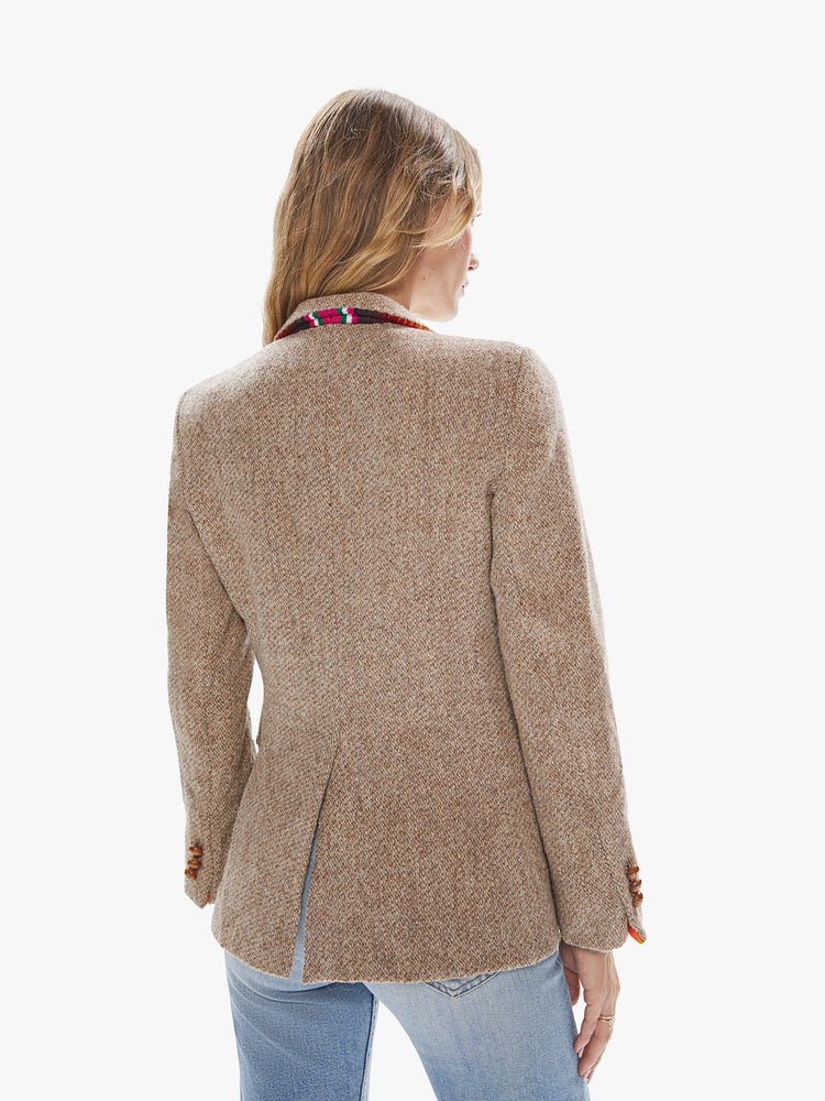 Back view of a woman wearing a light brown vintage tweed blazer with sarape blanket trim details and an oversized fit.