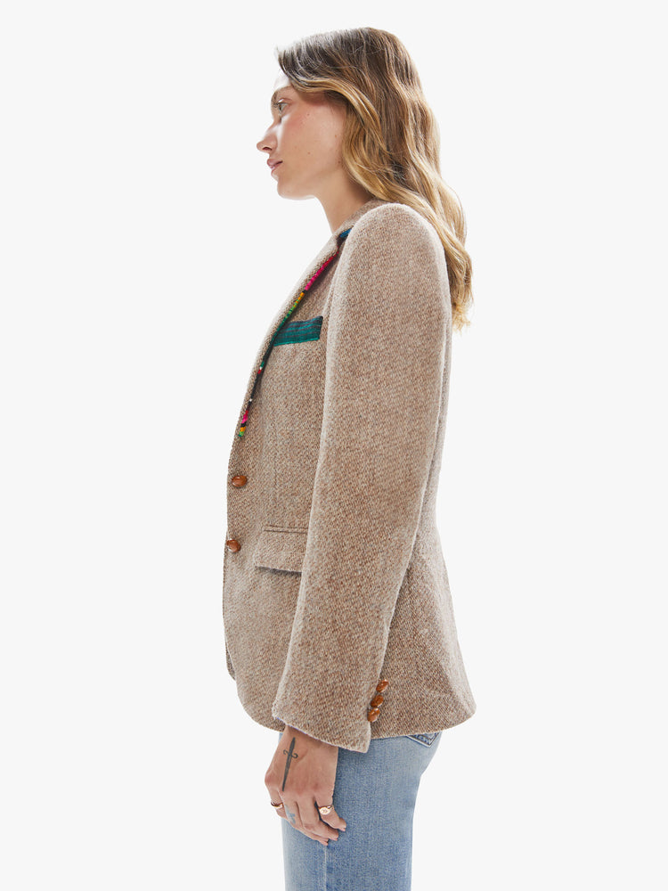 Side view of a woman wearing a light brown vintage tweed blazer with sarape blanket trim details and an oversized fit.