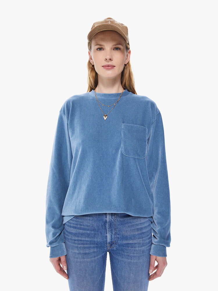 Front view of a women's long sleeve crew neck tee featuring a blue faded ribbed fabric, dropped sleeves, a chest pocket, and an oversized fit..