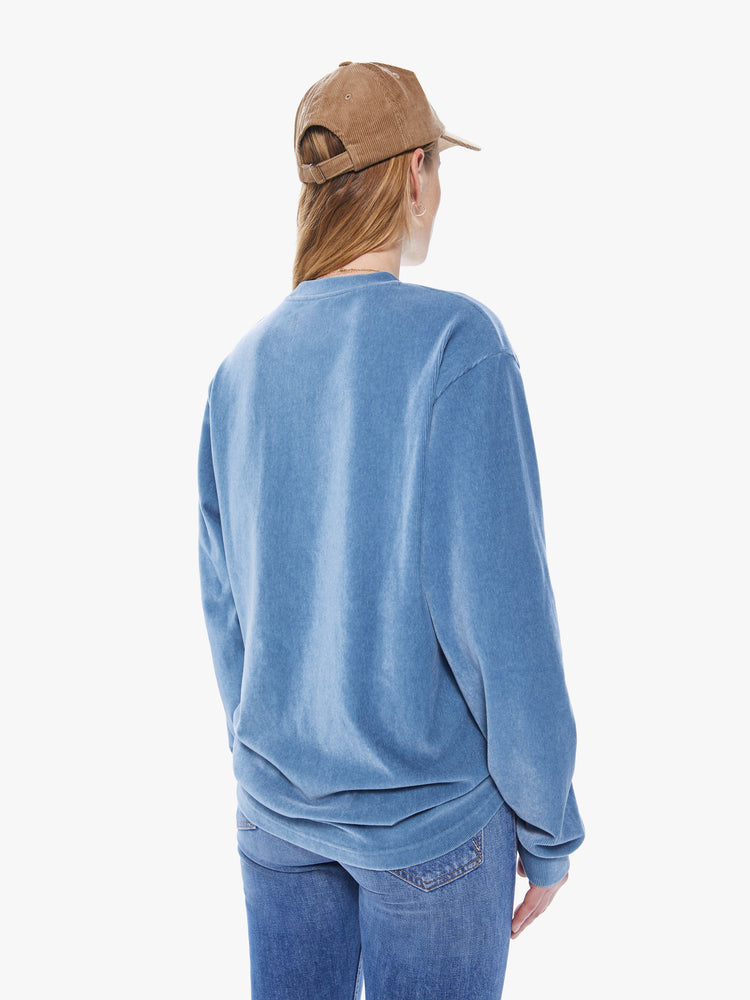 Back view of a women's long sleeve crew neck tee featuring a blue faded ribbed fabric, dropped sleeves, a chest pocket, and an oversized fit.